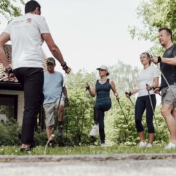 Gruppe wärmt sich für Nordic Walking auf