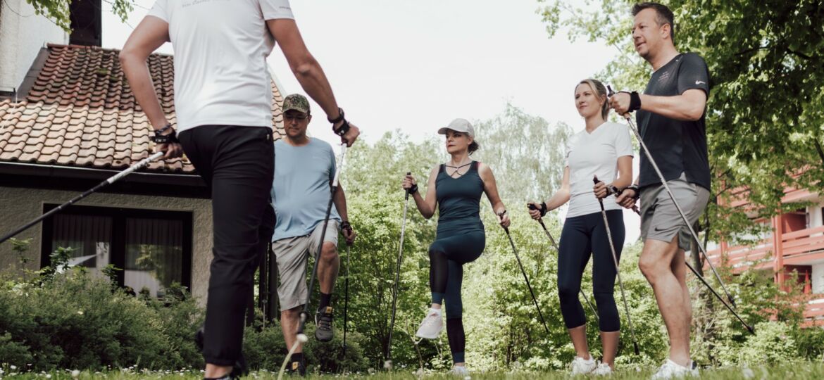 Gruppe wärmt sich für Nordic Walking auf